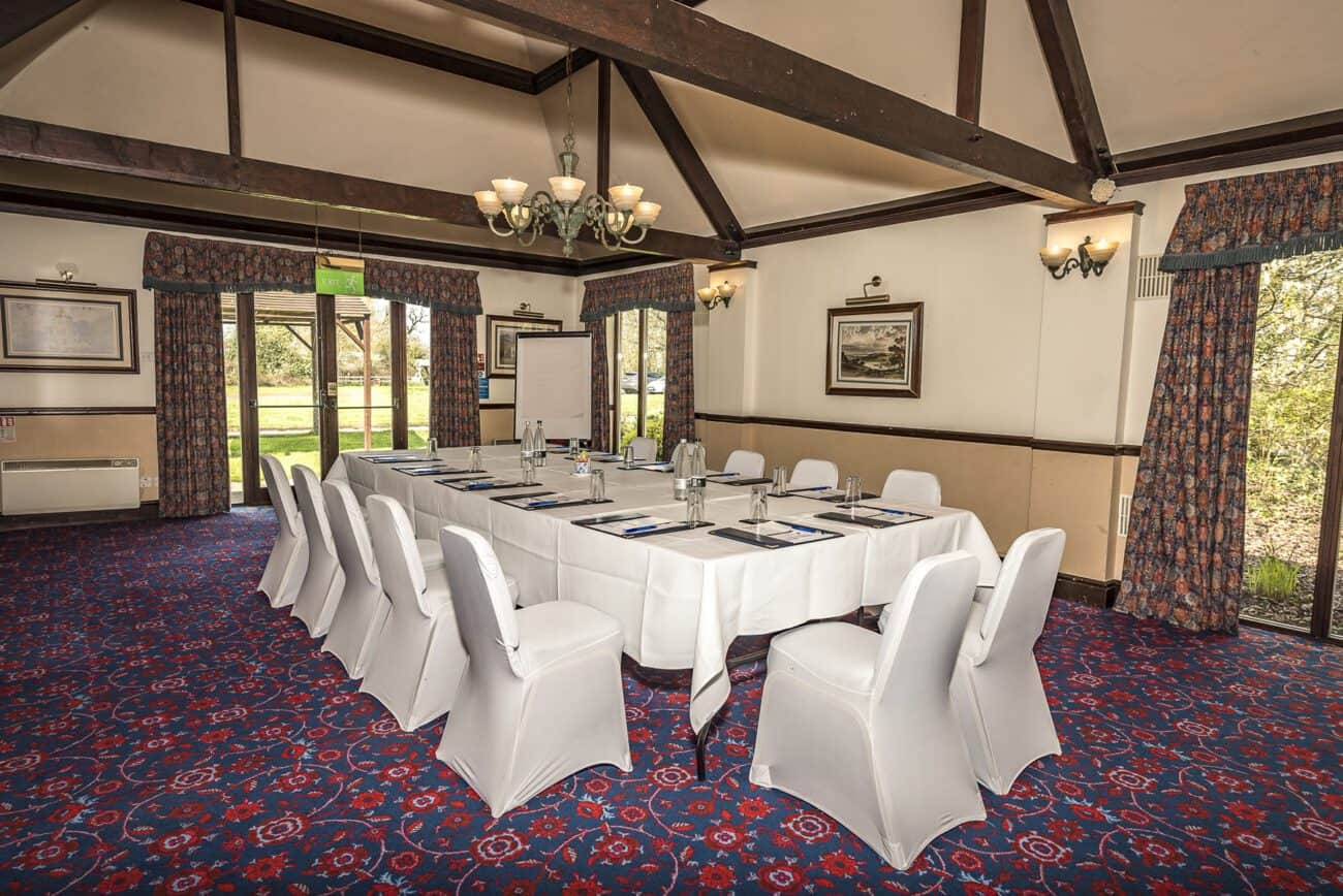 Conference room at Marston Farm Hotel with large table, white chair covers, and classic decor.