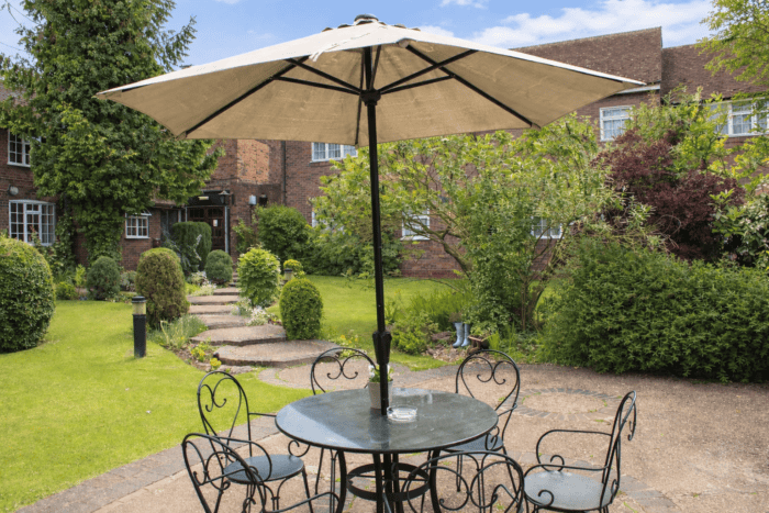 Outdoor seating area with table and umbrella at Marston Farm Hotel.